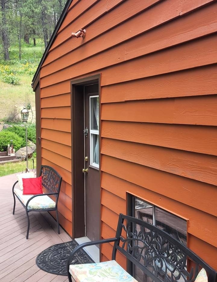 Exterior house painting Spokane - Vibrant orange wood cabin siding restoration