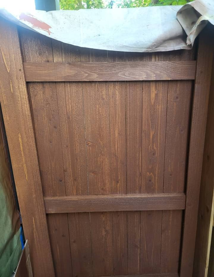 Close up of professional wood fence staining showing rich brown color