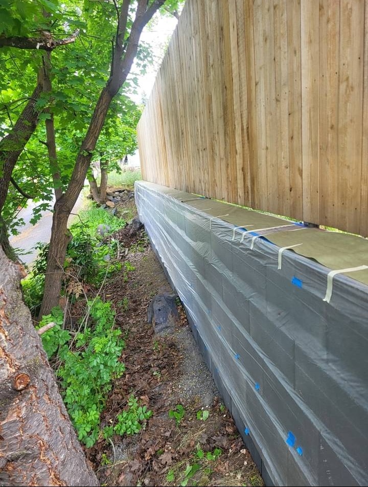 Retaining wall painting prep showing plastic masking and tape